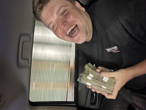 François, hilare, tenant une liasse de billets